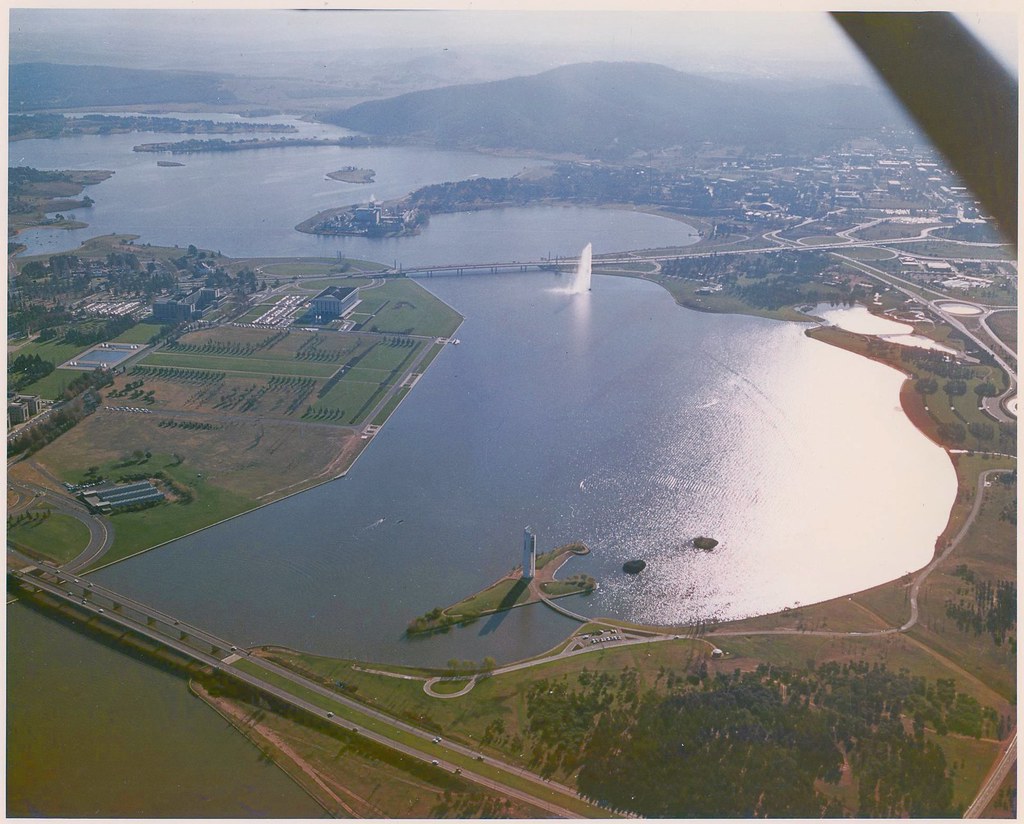 An aerial view across Lake Burley Griffin, with the National Carillon in the foreground and the Captain Cook Memorial Jet beyond.